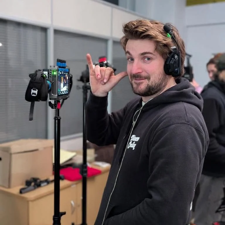Alex beside a wireless focus station wearing headphones