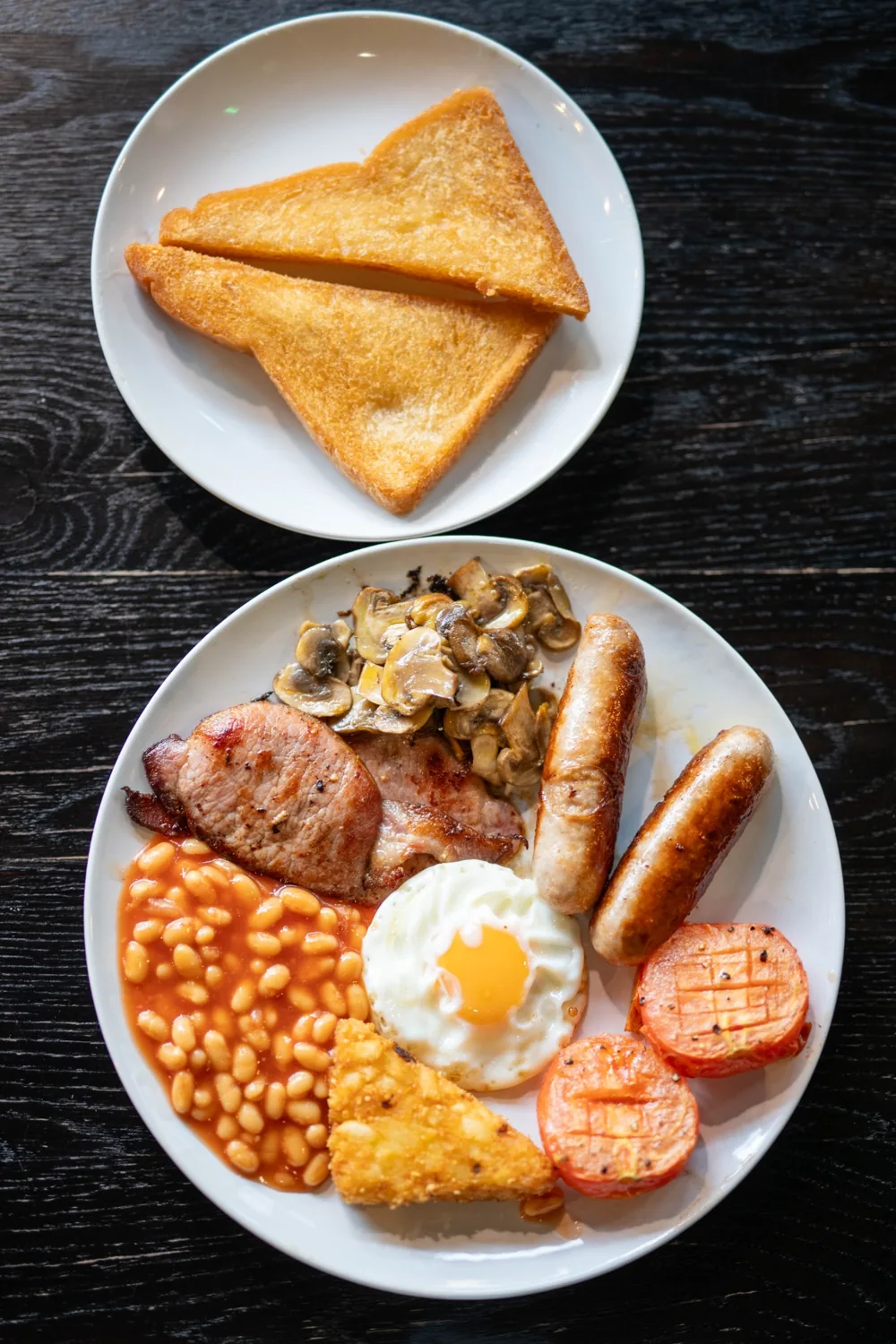 Overhead food photograph of breakfast and toast on a dark wooden table