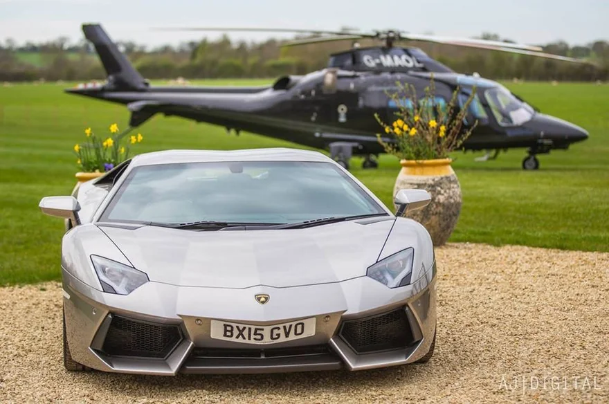 Silver sports car with a helicopter in the background