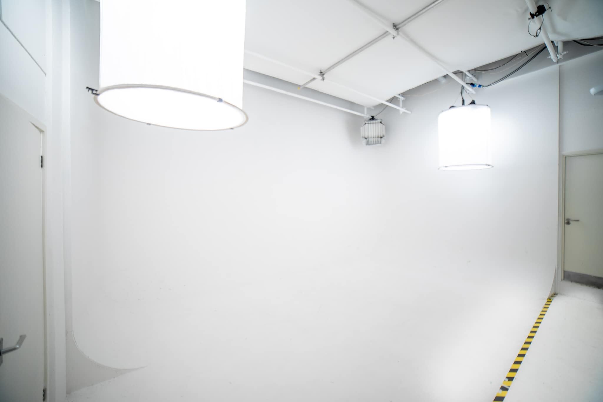 White infinity cove photography studio with overhead softbox lighting